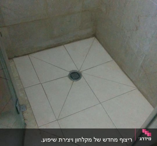 רצפת מקלחת מרוצפת עם ניקוז במרכז